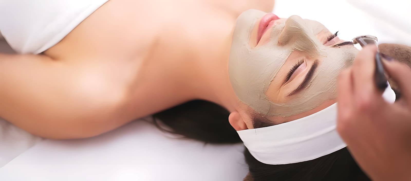 A client relaxing during a facial mask treatment